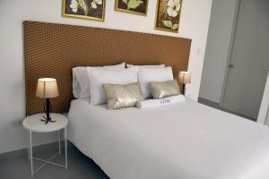 a bedroom with a large white bed with pillows at Azure apartahotel in Santa Marta
