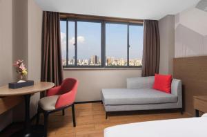 a hotel room with a couch and a table and a window at Borrman Hotel Wuhan Yellow Crane Tower Fuxing Road Metro Station in Wuhan +219 photos