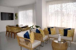 a living room with a couch and chairs and a table at Azure apartahotel in Santa Marta