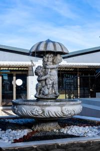 a fountain with an umbrella in front of a building at The Space Guesthouse Mondlo in Mondlo