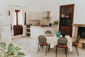 eine Küche mit einem Tisch und Stühlen in einer Küche in der Unterkunft La casa di Cò trilocale Centro storico Gallipoli in Gallipoli