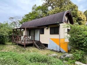 a small house with a porch and a deck at 森のやかた湯ったり館 