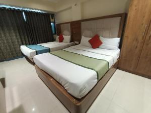Dos camas en una habitación de hotel con en Hotel RR inn-International Airport, en Bombay 4 fotos más