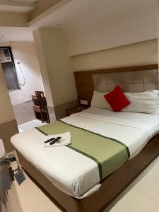 Un dormitorio con una cama grande con una almohada roja. en Hotel RR inn-International Airport, en Bombay
