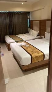 una habitación de hotel con 3 camas. en Hotel RR inn-International Airport, en Bombay