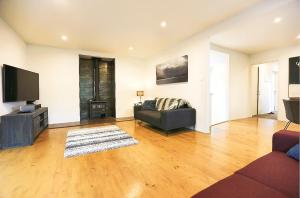 a living room with a couch and a flat screen tv at Stunning Mountain Views in Renovated Hamner Home in Hanmer Springs