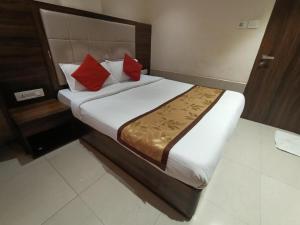 Un dormitorio con una cama grande con almohadas rojas. en Hotel RR inn-International Airport, en Bombay
