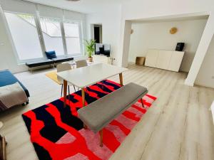 a living room with a table and a red and black rug at Messewohnung Meerbusch Duesseldorf in Meerbusch