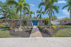 a home with palm trees in front of a driveway at Temporary Sanity in Sarasota