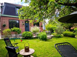 a backyard with a table and chairs and a house at Le cottage de Cassandre in Sebourg