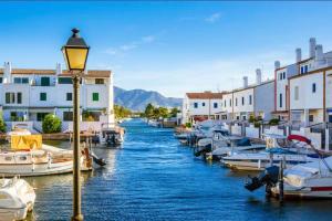 Un grupo de barcos atracados en un canal con edificios en Apartamento en frente al mar de Empuriabrava, en Empuriabrava