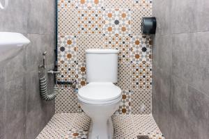 a bathroom with a toilet and a tiled wall at Newly 4BR Cottage House Retreats with Free Parking in Butterworth +28 photos