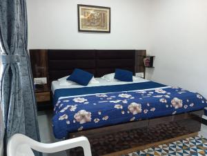 a bedroom with a bed with a blue comforter at Palm -1 in Jaipur