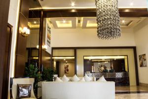 a lobby with a white couch and a chandelier at Hotel Southern Comfort in Chennai