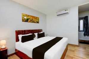 a bedroom with a large white bed in a room at Super Townhouse Vanasthalipuram Near Deer National Park in Hyderabad +24 photos