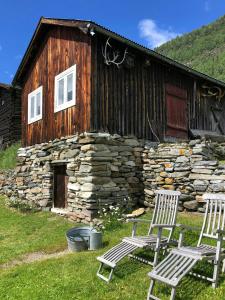 two chairs sitting in front of a stone building at Farm In The Heart Of Gudbrandsdalen in Moss
