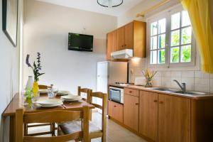 a kitchen with a wooden table and a dining room at Irena Studios & Apartments in Sarláta