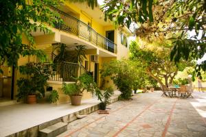 a building with a courtyard with plants and tables at Irena Studios & Apartments in Sarláta