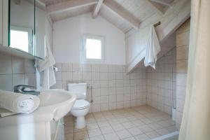 a white bathroom with a toilet and a sink at Irena Studios & Apartments in Sarláta +40 photos
