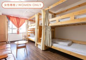 a room with two bunk beds and a table at Almas Guest House(アルマス） in Nagasaki