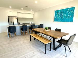 a kitchen and dining room with a wooden table and chairs at The Blue Wren in Emu Bay