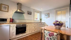 a kitchen with white cabinets and a counter top at Elsmere Heritage Gardens & Accom in Launceston
