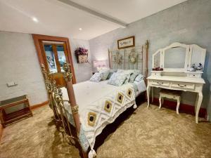 Un pat sau paturi într-o cameră la Elsmere Heritage Gardens & Accom