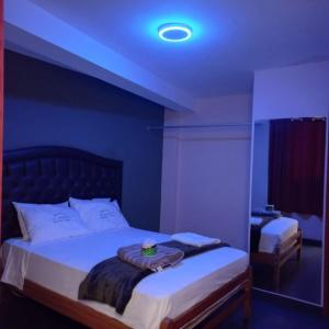 a bedroom with a large bed with a blue ceiling at Hostal El Bosque in Huánuco +12 photos