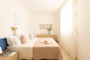 a white bedroom with a bed and a table at ANIMA JESOLO - DRAGO VILLAGE, Beach & Pool, 2 Parkings in Lido di Jesolo