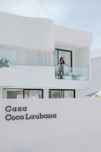 a person standing on the balcony of a building at Brand new Luxury 2 BR Villa CASA COCO LAUBANA in Uluwatu