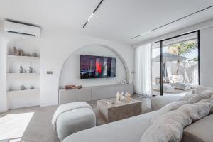 a living room with white furniture and a tv at Brand new Luxury 2 BR Villa CASA COCO LAUBANA in Uluwatu