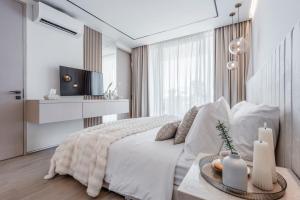 a white bedroom with a bed and a tv at Brand new Luxury 2 BR Villa CASA COCO LAUBANA in Uluwatu +22 photos