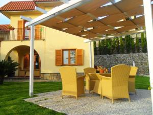 a patio with a table and chairs under a pergola at Villa Talea in SantʼAgata sui Due Golfi