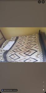 a bed with a black and white comforter at Robeck's Guest House in Gatunga
