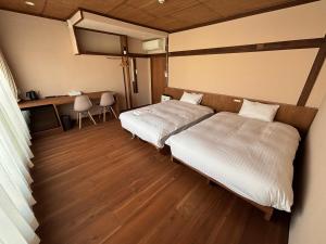 een slaapkamer met twee bedden en een tafel en stoelen bij nirasakiyaSTAY in Nirasaki +100 foto's