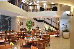 un restaurante con mesas y sillas de madera y una escalera en Sleep Inn Paseo Las Damas, en San José