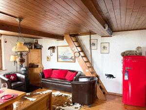 a living room with a couch and a red refrigerator at Authentique chalet familial in Nendaz