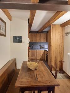 a kitchen with a wooden table with a basket on it at Le Panoramique, La Salle Derby Village in Villaret