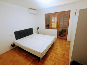 a bedroom with a bed in a room with a wooden floor at Novska Vidikovac in Novska