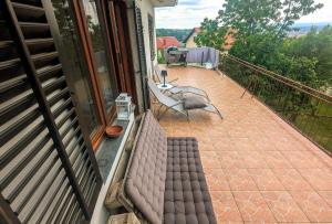 a balcony with a couch and chairs on a patio at Novska Vidikovac in Novska