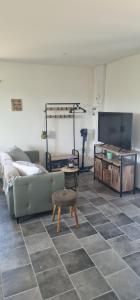 a living room with a couch and a flat screen tv at Le petit Marius in Fayence