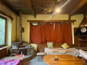 a living room with a red curtain and a table at Ananda grham in Kotla