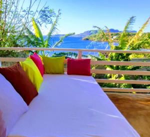 a couch with colorful pillows sitting on a balcony at Maison en bord de mer in Diego Suarez