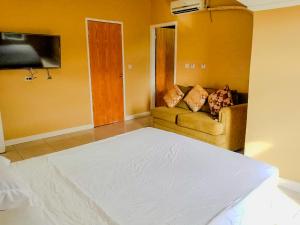 a living room with a bed and a couch at Candy's Palace Apartments -Dominica's Best Hilltop Haven in Portsmouth