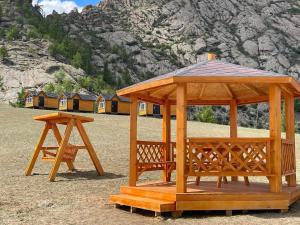 a wooden gazebo and a table in a field at Ko Terelj Resort in Yoliin Hural