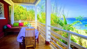 a porch with a table and a view of the ocean at Maison en bord de mer in Diego Suarez