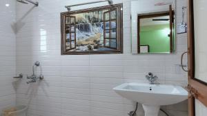 ein Badezimmer mit Waschbecken und Spiegel in der Unterkunft Adventure Inn 20 Metre from Swimming Pool in Dharamshala + 32 Fotos