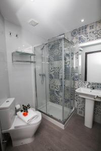 a bathroom with a shower and a toilet and a sink at Hostal Boutique Bajamar in Nerja