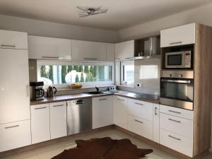 a kitchen with white cabinets and stainless steel appliances at Villa WoW in Zastań