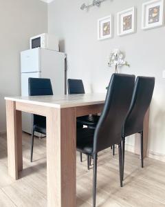 a wooden table with black chairs and a white refrigerator at Sissy Tenerife Apartman in San Miguel de Abona +17 photos